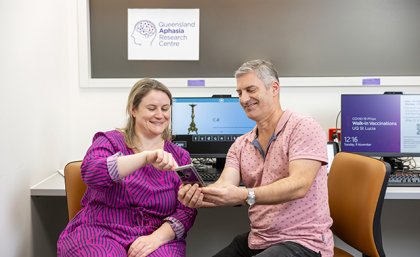 QARC researcher Jessica Campbell and a program participant. QARC researcher Jessica Campbell showing a person with aphasia an app on a phone.